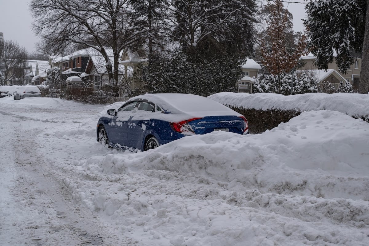 Cars buried in snow on unkept roads